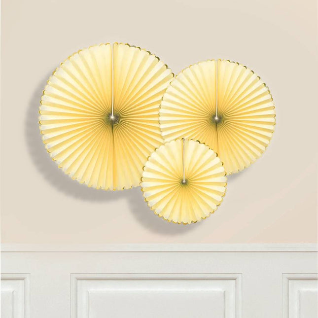 Lichtgele waaiers met een gouden rand hangen aan een muur