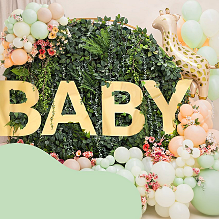 groen bosje met gouden letters baby omringd door groene en creme ballonnen