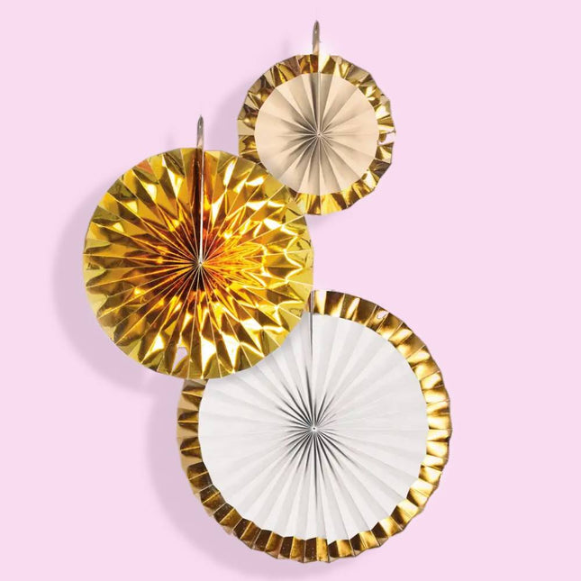 3 waaiers in de kleuren goud, beige en wit op een roze achtergrond