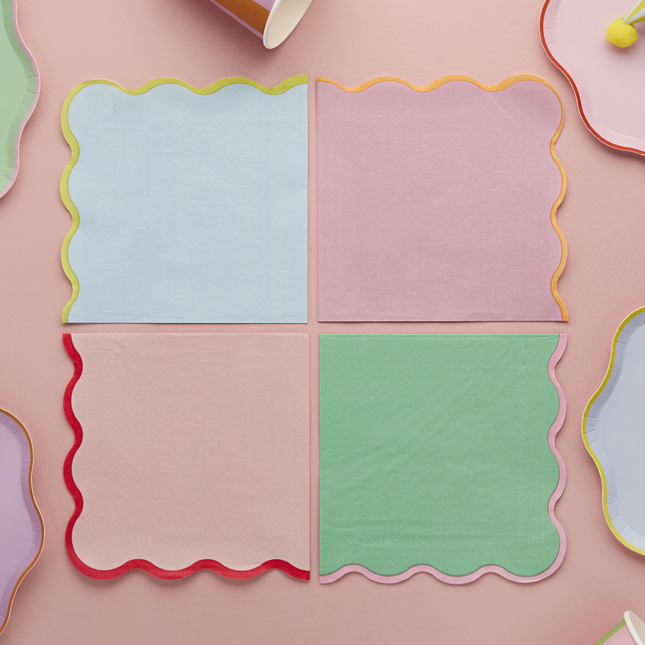 pastel servetten met gekleurde ribbelrand liggen op een roze tafelkleed