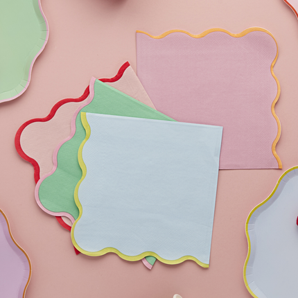 pastel servetten met gekleurde ribbelrand liggen op een roze tafelkleed