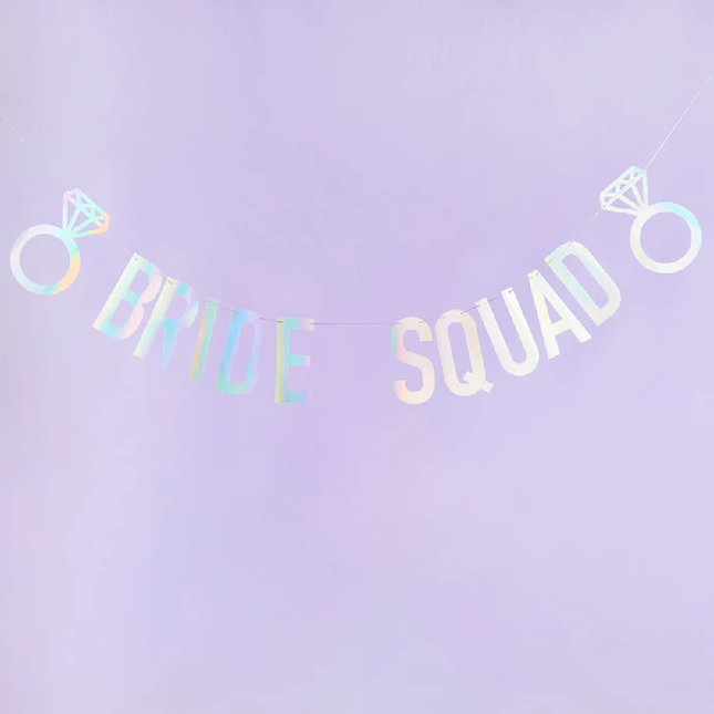 Iridescent slinger met de tekst bride squad en twee trouwringen op een lila achtergrond