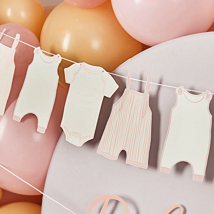 slinger met rompertjes in het wit met roze hangt voor nude, roze en witte ballonnen