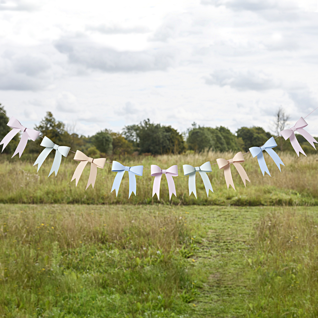 slinger met pastel strikjes hangt in een grasveld