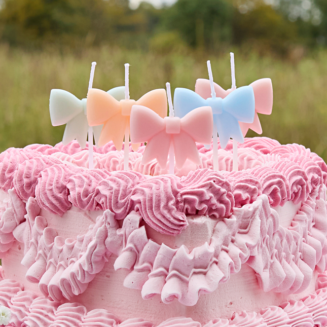 verjaardagskaarsjes strikjes pastel zitten in een roze taart