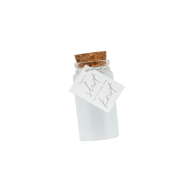 transparant shotglaasje met kurk erop en een briefje met de tekst take a shot we've tied the knot