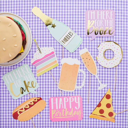 foody photo booth props met een pizzapunt, donut en taart op een paars met wit geblokte achtergrond