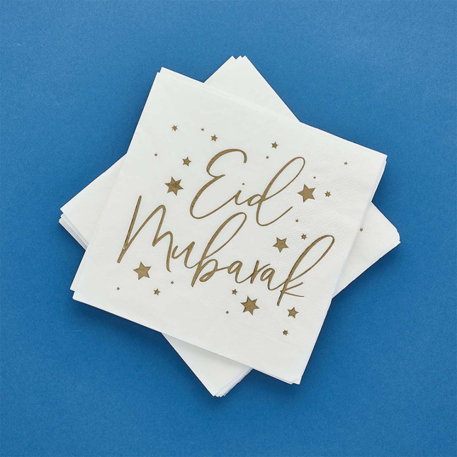 Witte servetten met gouden tekst Eid Mubarak en gouden sterren op een donkerblauwe achtergrond