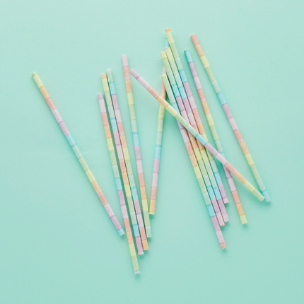 Regenboog rietjes in pasteltinten op een mintgroene achtergrond