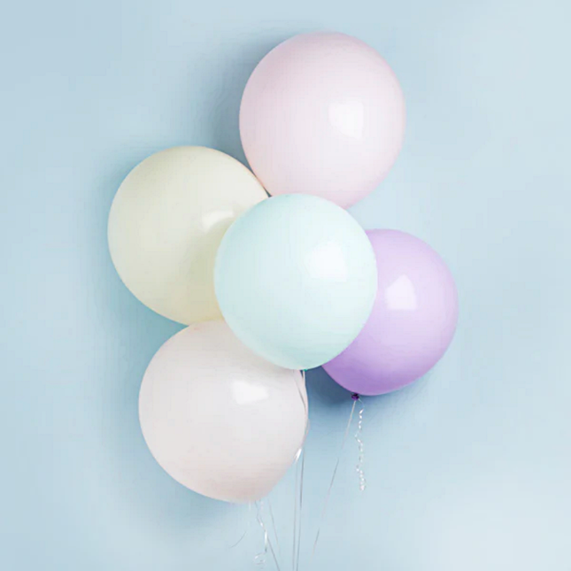 pastelkleurige reuzeballonnen voor een blauwe muur