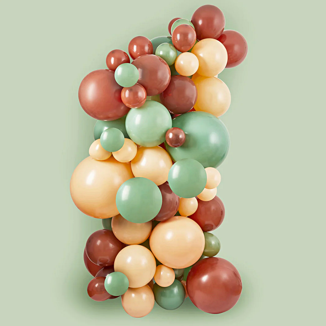 ballonnenboog met bruine, nude en saliegroene ballonnen voor een groene achtergrond