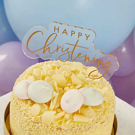 transparant en gouden taart topper met de tekst happy christening in een gele taart