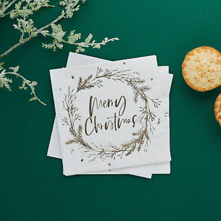 Witte servet met gouden bedrukking merry christmas op donkergroene achtergrond