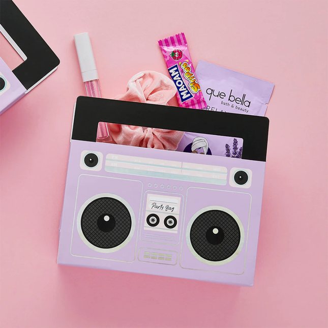 paarse boombox ligt op een roze achtergrond en is gevuld met snoep