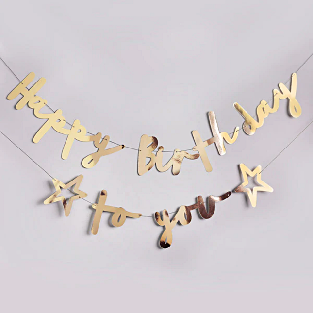 gouden letterbanner happy birthday to you op een grijze muur