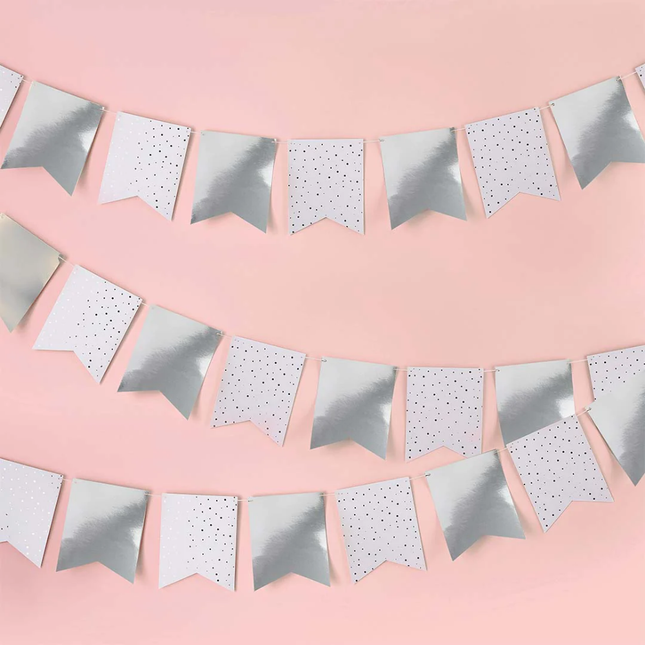 zilveren en witte vaantjes voor een lichtroze muur