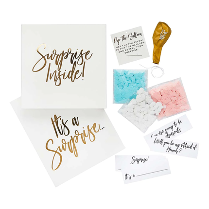 inhoud van een surpise box in het wit en goud met roze en blauwe confetti