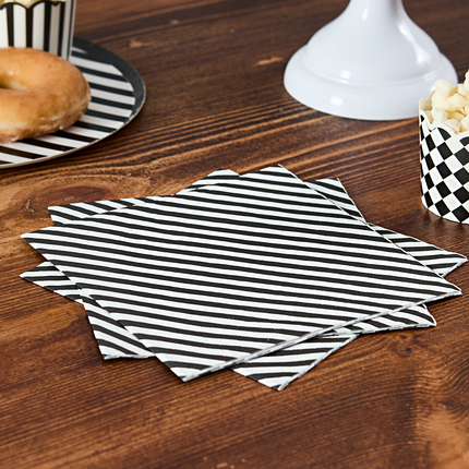 zwart wit gestreepte servetten liggen op een bruine tafel