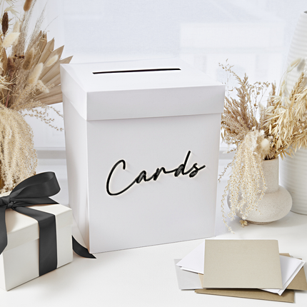 witte kaartendoos met acryl tekst cards in het zwart staat tussen zwarte en creme versiering
