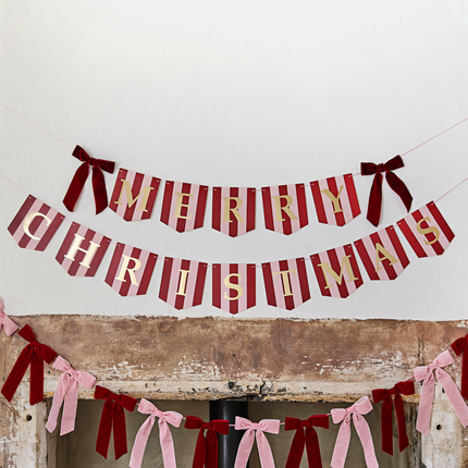 rood en roze gestreepte slinger met gouden tekst merry christmas en rode velvet strikjes