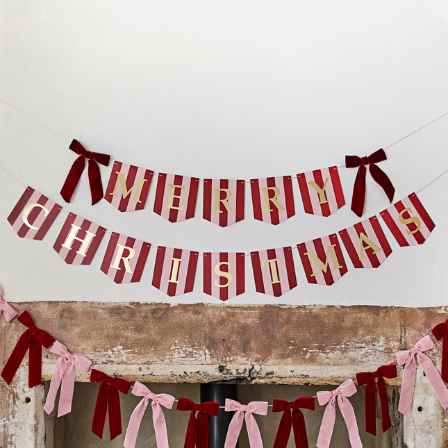 rood en roze gestreepte slinger met gouden tekst merry christmas en rode velvet strikjes