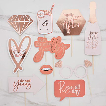 Lichtroze, rose gouden en witte photo booth accessoires op een marmeren achtergrond