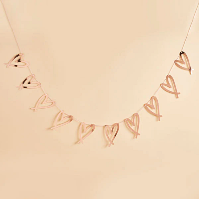 Rose gouden hartjes slinger op lichtgele en beige achtergrond