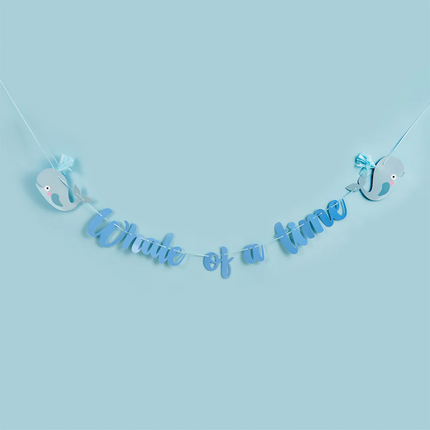 blauwe slinger met de tekst whale of a time en twee walvissen voor een pastelblauwe achtergrond
