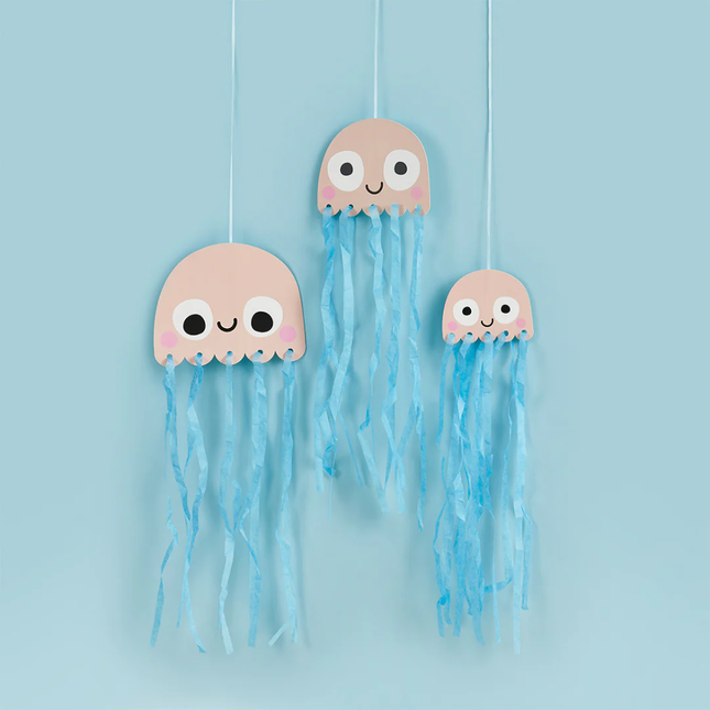 hangende papieren kwallen in het roze met blauwe tassels en schattige gezichtjes hangen voor een pastelblauwe achtergrond