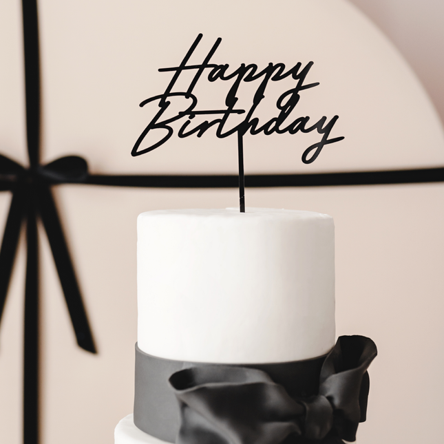 witte taart met zwarte happy birthday versiering