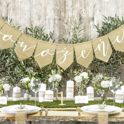 Versierde tafel met witte kaarsen bloemen een nummer 1 en een stoffel vlaggenlijn