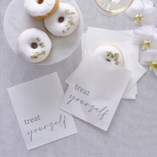 Witte zakjes met de tekst treat yourself zijn gevuld met donuts