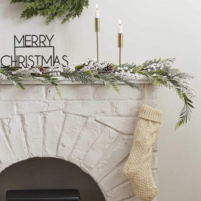 Schouw met kunsttakken met witte besjes en sneeuw, kerstsok en standaard met merry christmas