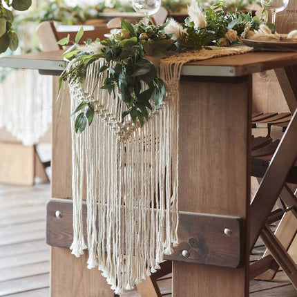 Gedekte tafel met macrame tafelloper met groene decoratie