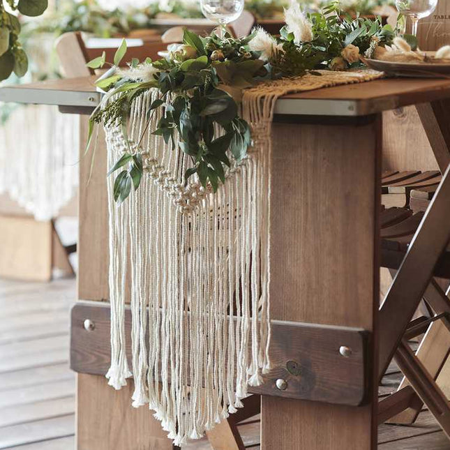 Gedekte tafel met macrame tafelloper met groene decoratie