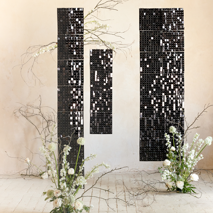 ruimte versierd met zwarte panelen met vierkantjes en witte kunstbloemen
