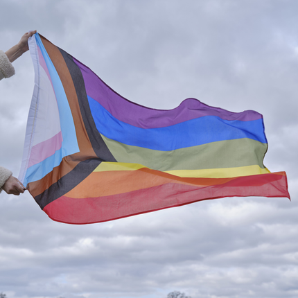 regenboog pride vlag LGBTQ+ wordt buiten vastgehouden voor een bewolkte lucht