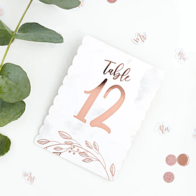 wit en rose goud tafelkaartje ligt naast eucalyptus