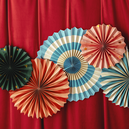vrolijk gekleurde waaiers hangen aan een rood doek
