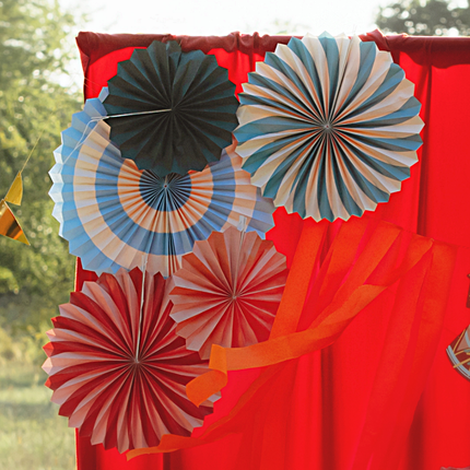 vrolijk gekleurde waaiers hangen aan een rood doek in de natuur