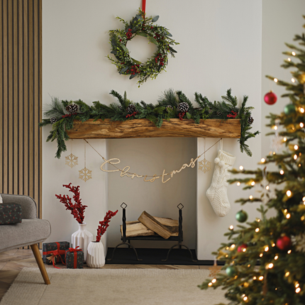 Huiskamer versierd met groene, rode en houten kerstversiering