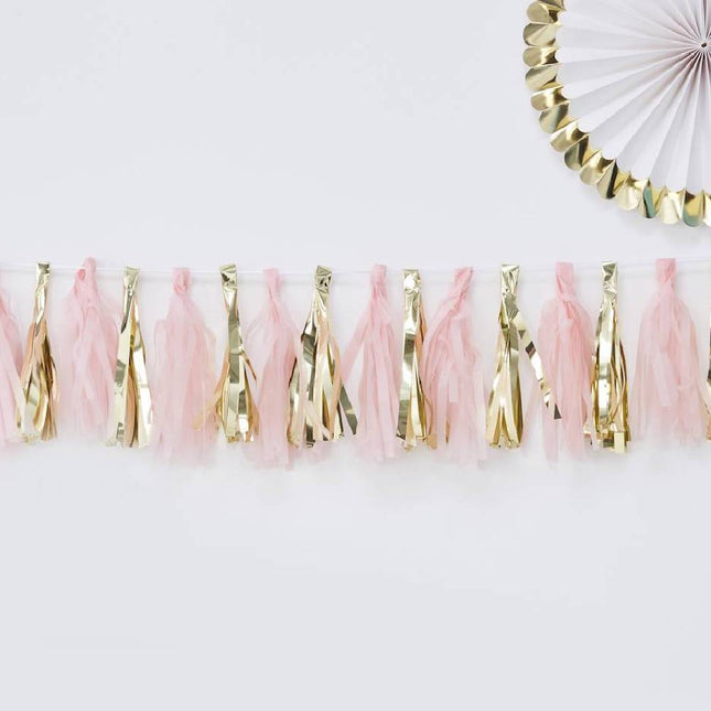 Draad met daaraan roze en gouden tassels en daarboven een wit met gouden waaier