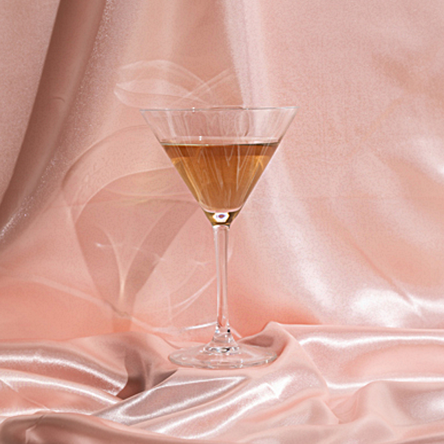 cocktailglas voor een perzikkleurig satijnen doek