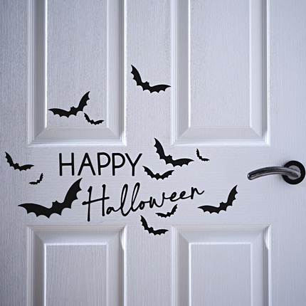 Zwarte stickers happy halloween en vleermuizen zitten op een witte deur