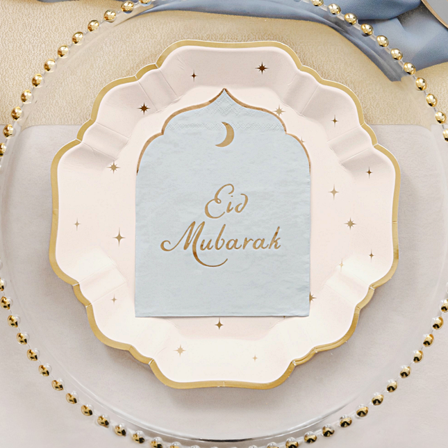 lichtblauwe met gouden servetten met de groet eid mubarak liggen op beige bordjes met gouden sterren
