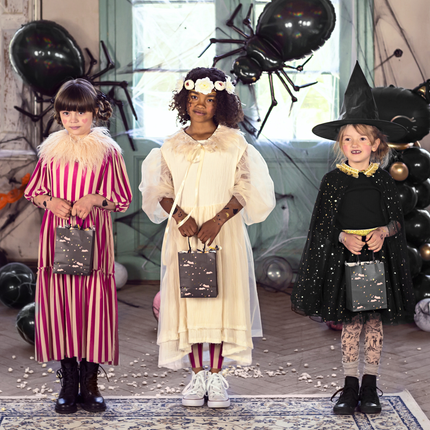 drie meisjes met halloween kostuums bestaande uit een clown en een heks