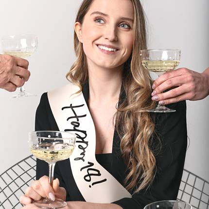 meisje met een creme sjerp met de zwarte tekst happy 18
