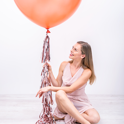 rose gouden tassels zitten onder een ballon