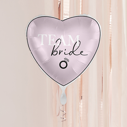 roze folieballon met de tekst team bride in het wit en zwart voor een rose gouden achtergrond