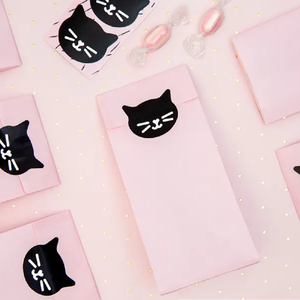 Roze zakjes dichtgeplakt met een zwarte sticker in de vorm van een kat